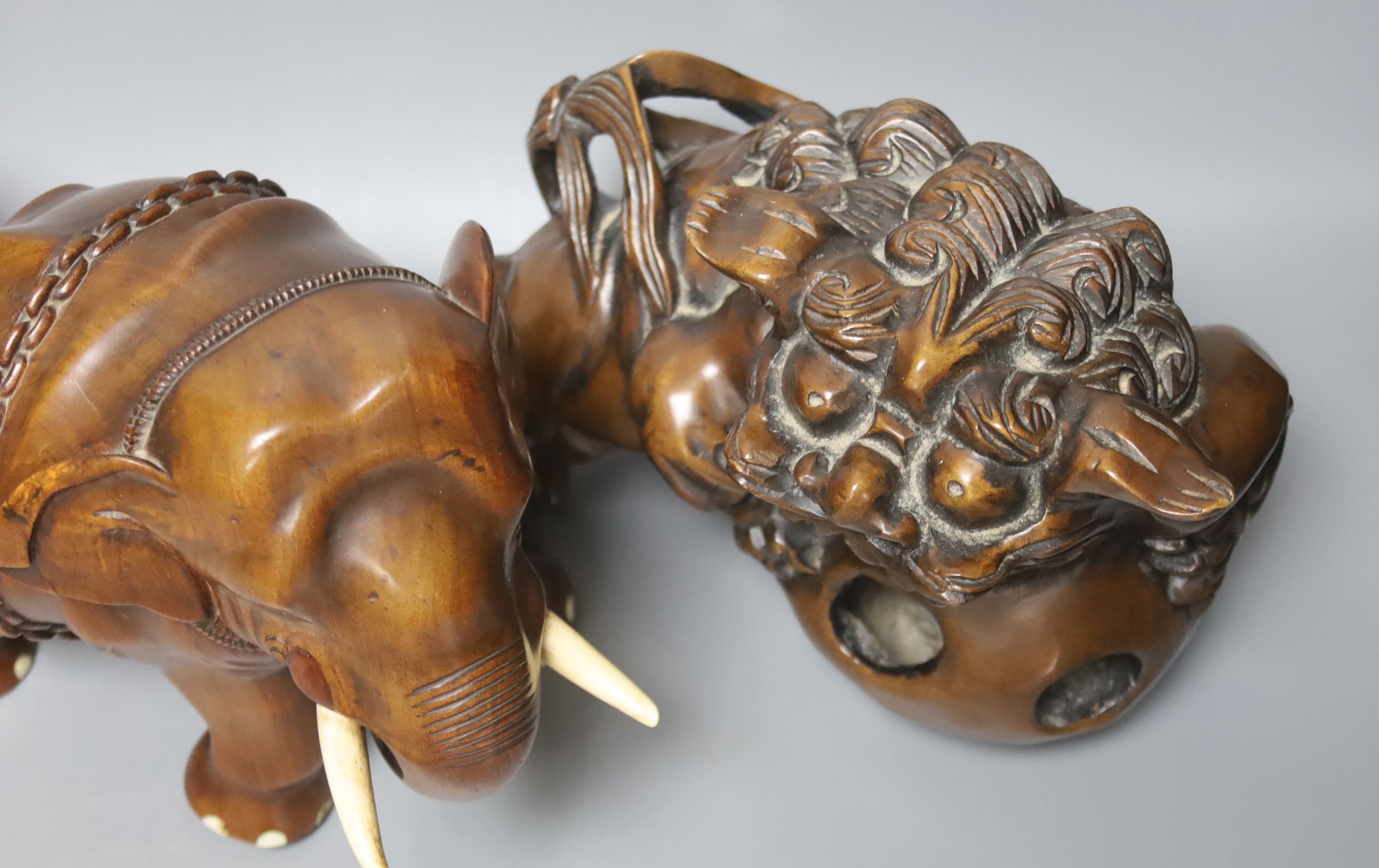 An Indian padouk wood figure of an elephant and a pair of wood figures of Buddhist lions 17cm